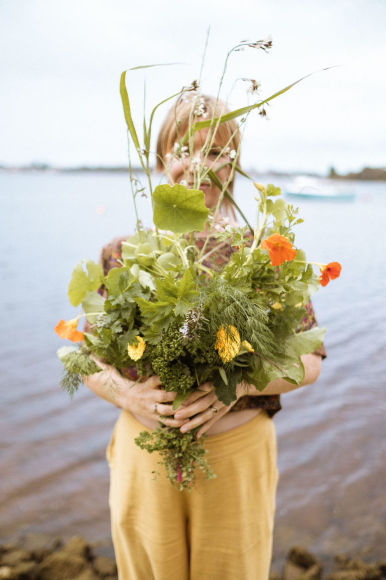 Naturopath holding a bouquet made of leafy greens and herbs