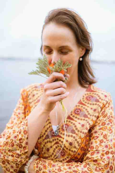 Woman sniffing nastursiums and wormwood bouquet