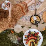 A just picnic rug with someone eating a plate of healthy food. Repressing an article on keeping you microbiome healthy